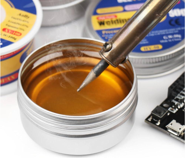 Soldering iron tip immersed in a tin of flux paste