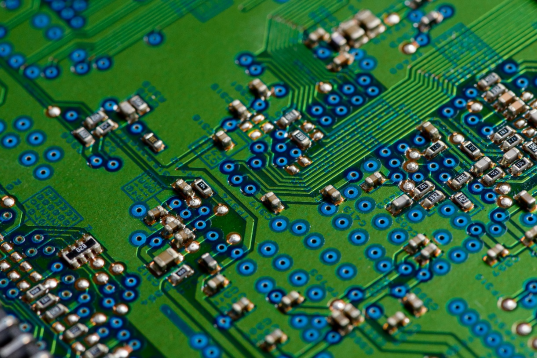 Green PCB with blue components, intricate design.